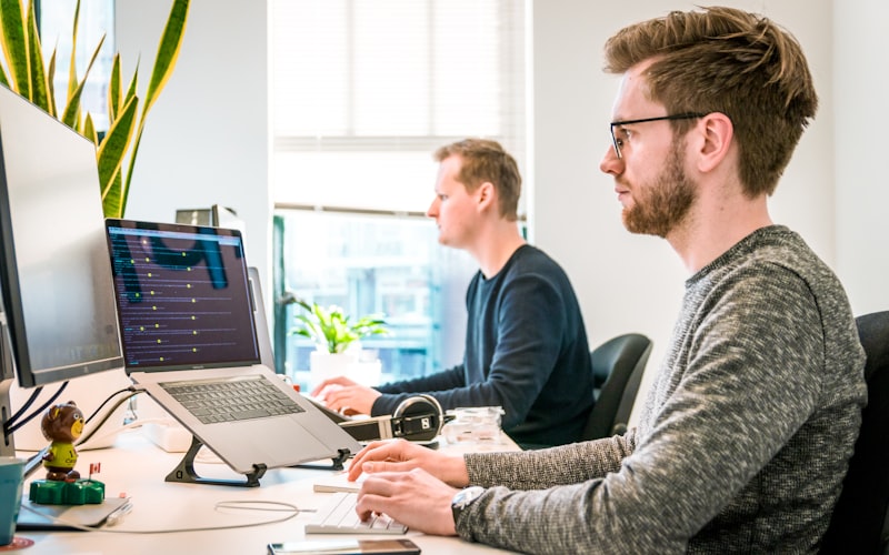 Team collaborating on laptops in modern office